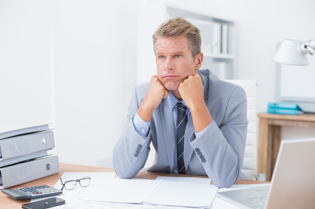 Worried businessman sitting at work in his office