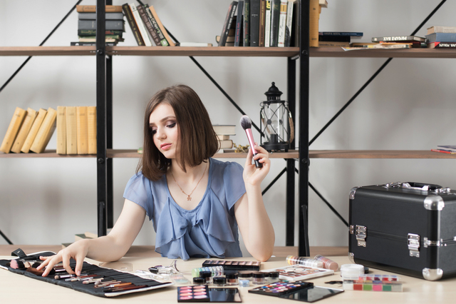 Beautiful makeup artist choosing brush from set