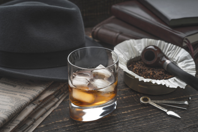Whiskey with ice , pipe hat and newspaper